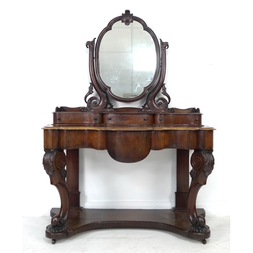 293 - A Victorian mahogany dressing table, with oval mirror on shaped supports, three trinket drawers, the... 