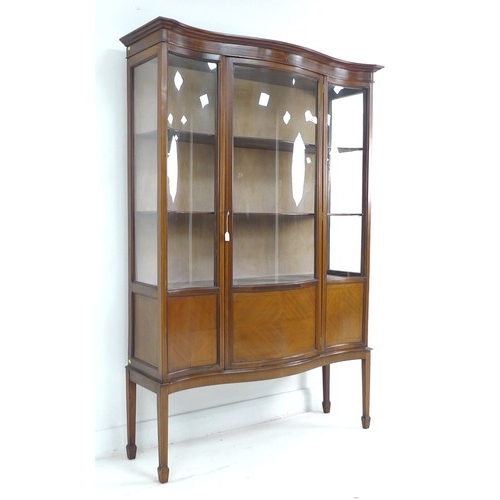 308 - An Edwardian mahogany serpentine fronted display cabinet, line inlaid, bowed glass, three fabric lin... 