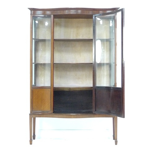 308 - An Edwardian mahogany serpentine fronted display cabinet, line inlaid, bowed glass, three fabric lin... 