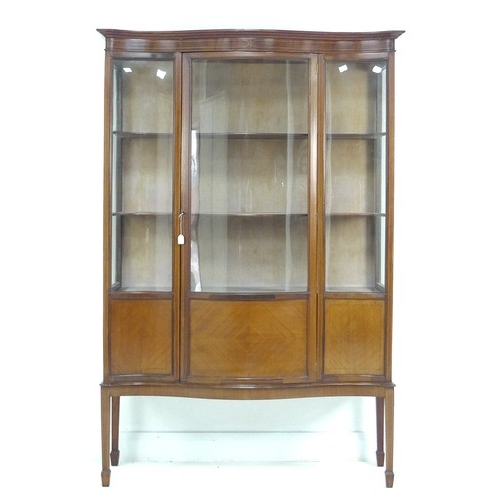 308 - An Edwardian mahogany serpentine fronted display cabinet, line inlaid, bowed glass, three fabric lin... 