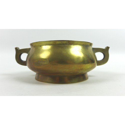 25 - A Chinese polished bronze censer, of twin handled squat circular form, raised on a high foot rim, ca... 