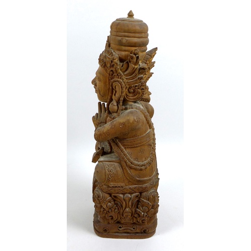 13 - An Indonesian carved wooden deity statue, mid 20th century, modelled in sitting pose with cross legs... 