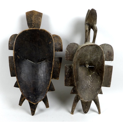 97 - Two Ivory Coast Senufo face masks or Kpelie, of elongated form, with flanges to the sides, the small... 