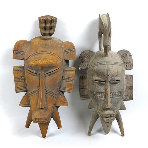 97 - Two Ivory Coast Senufo face masks or Kpelie, of elongated form, with flanges to the sides, the small... 