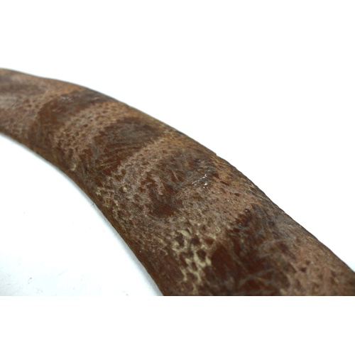 96 - An Australian Aboriginal boomerang, mid 20th century, likely stone or tooth tula carved, and with pl... 