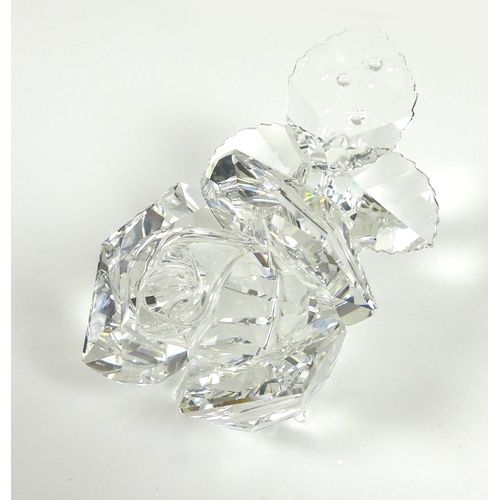 78 - A Swarovski Crystal sculpture, modelled as a single stemmed rose, the leaves with droplets of water,... 