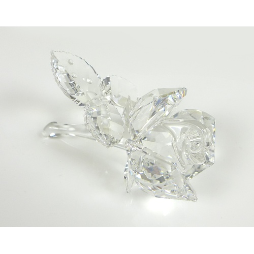 78 - A Swarovski Crystal sculpture, modelled as a single stemmed rose, the leaves with droplets of water,... 