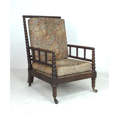 314 - An early Victorian oak bobbin turned armchair, with loose upholstered seat and back cushions, raised... 