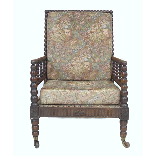 314 - An early Victorian oak bobbin turned armchair, with loose upholstered seat and back cushions, raised... 