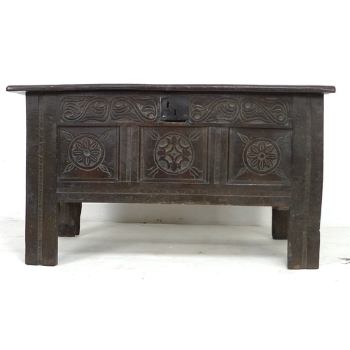 295 - A 17th century oak coffer, the front with three floral carved roundels and scroll frieze above, thre... 