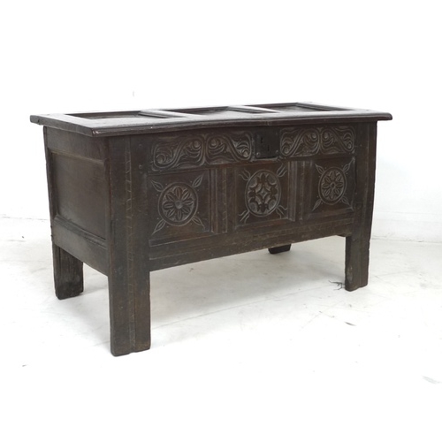 295 - A 17th century oak coffer, the front with three floral carved roundels and scroll frieze above, thre... 