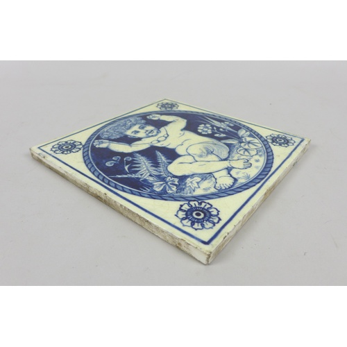 63 - A 19th century Mintons blue and white tile, featuring a cherub holding up a necklace, bearing marks ... 