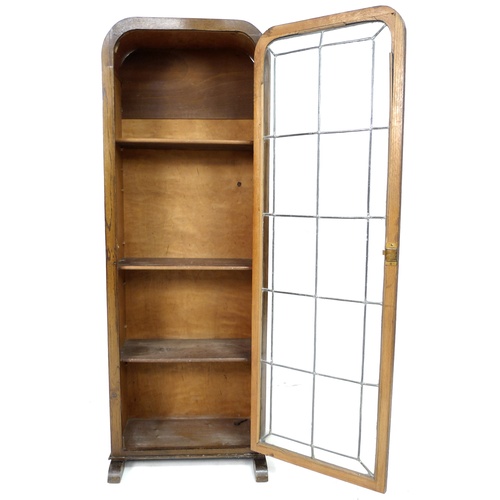 277 - An early 20th century oak bookcase, featuring an arched top, a single leaded glazed door, with curve... 