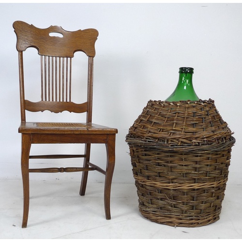 241 - An American large wicker bound green glass demijohn bottle, together with an American oak chair with... 