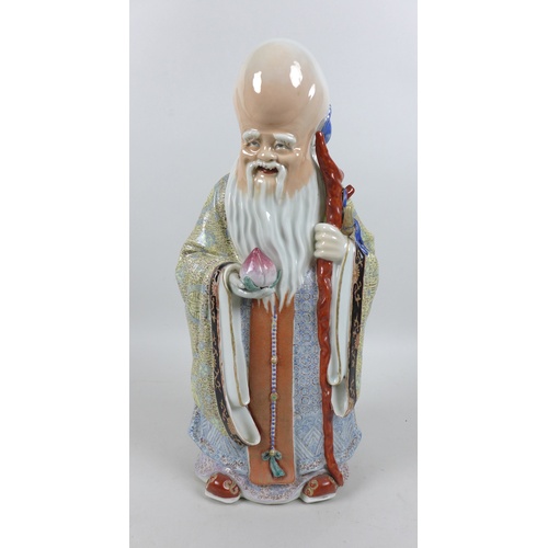 29 - A modern Chinese porcelain figure, modelled as Shou Lao, the god of longevity, standing holding a st... 
