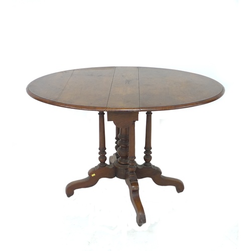 304 - A Victorian walnut drop leaf table, the circular surface with moulded edge, raised on central and fo... 