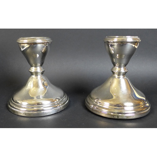 25 - A group of silver and silver plated items, comprising a pair of silver weighted dwarf candlesticks, ... 