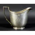 A George III silver milk jug, of helmet form with reeded rim and handle decoration, monogram engrave... 