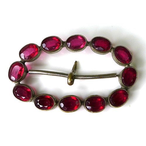124 - A decorative buckle set with twelve magenta coloured oval 'stones', each 7 by 5 by 3mm, possibly Geo... 