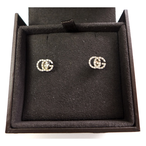 139 - A pair of Gucci Italian 18ct white gold and diamond set earrings, in the form of the double G monogr... 