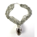 A geode and moss agate necklace, the agate geode with calcite crystal interior, and having natural f... 