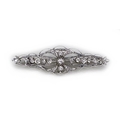 An Art Nouveau 18ct white gold and diamond bar brooch, with scrolled wire design set with twenty thr... 
