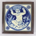 A 19th century Mintons' blue and white tile, featuring a cherub holding up a necklace, bearing marks... 