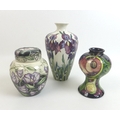 Three pieces of Moorcroft pottery, comprising a Queen's Choice slender baluster form vase, with impr... 