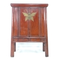 A modern Chinese style cabinet, of tapering form with red lacquered finish, brass butterfly shaped l... 