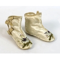A pair of Edwardian baby's boots, circa 1900, leather soles and cream silk, with two bows to the sid... 