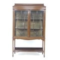 An Edwardian mahogany crossbanded and line inlaid display cabinet, twin glazed doors enclosing two s... 