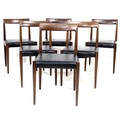 A set of six German teak dining chairs, circa 1970, of slender modern design, with black faux leathe... 