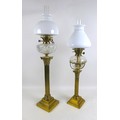 A Victorian brass paraffin lamps, both with clear glass reservoirs on a Corinthian columns and squar... 