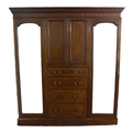 An Edwardian mahogany compactum wardrobe, with inlaid and crossbanded decoration, outswept cornice o... 
