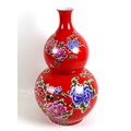 A large modern Chinese porcelain double gourd vase, with printed floral decoration against a red gro... 