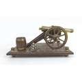A mid 20th century brass and oak model canon on stand, overall 31 by 17 by 13cm high.