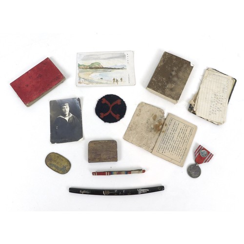 67 - A collection of WWII Japanese ephemera, comprising a Red Cross medal with blue rosette, a Japanese b... 