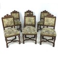 A set of six oak framed dining chairs, with carved top rails, over stuffed upholstered seats and bac... 