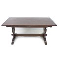 A modern dark stained oak dining table, rectangular surface raised on shaped trestle ends with cut o... 