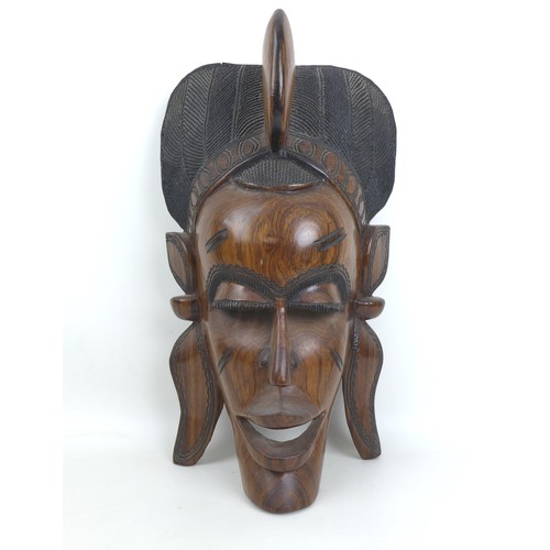 34 - Two modern African carvings, one carved as a mask with headdress, 28 by 16.5 by 48.5cm long, the oth... 