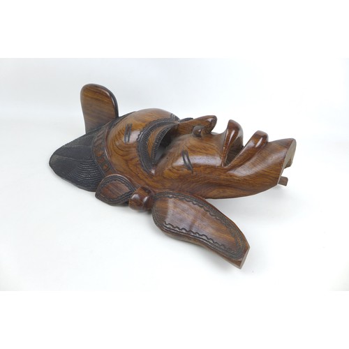 34 - Two modern African carvings, one carved as a mask with headdress, 28 by 16.5 by 48.5cm long, the oth... 