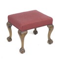 A Victorian footstool with cabriole legs, ball and claw feet, upholstered in red and cream spotted f... 