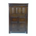 A mid 20th century dark stained oak drinks cabinet, in Old Charm style, applied linenfold decoration... 