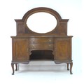 An Edwardian oak sideboard, arched back with inset oval mirror, the base centally with two bow front... 