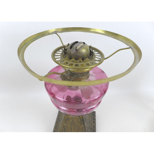 48 - A Victorian paraffin lamp, with cranberry glass reservoir, base 23 by 33cm high, etched clear glass ... 