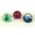 A group of three Caithness paperweights, comprising Spring Festival, an unnamed red spiral, and an u... 