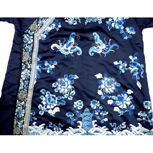 25 - An early 20th century silk Chinese robe, with navy blue ground and intricately embroidered with butt... 