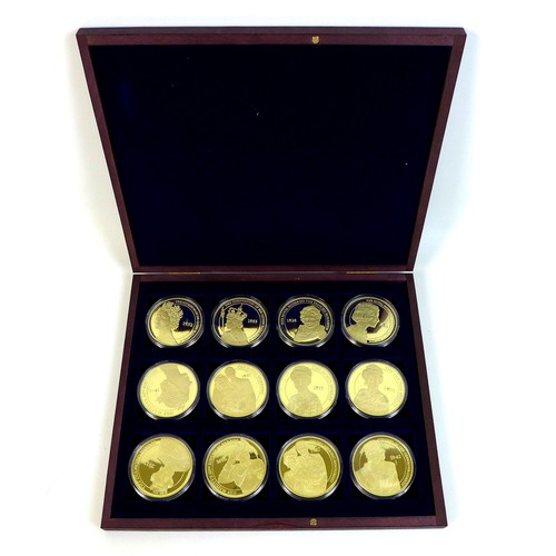 73 - A QEII commemorative coin set, twelve gold plated 50mm coins 'celebrating Her Majesty Queen Elizabet... 