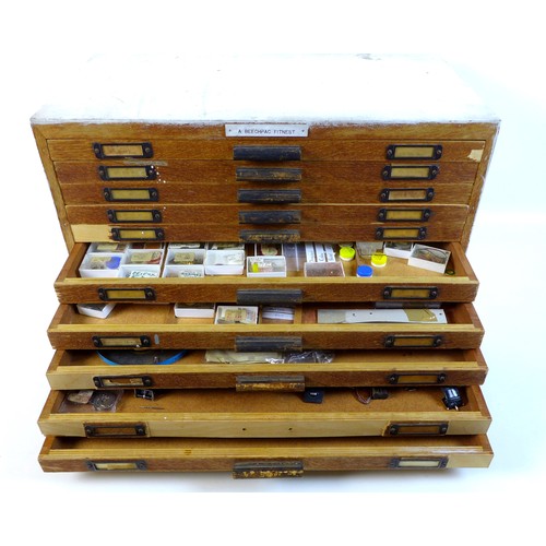 92 - A collection of watch parts, contained within an oak ten drawer table top chest, labelled 'A Beechpa... 