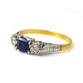 An 18ct gold, platinum, sapphire and diamond ring, the central square cut sapphire, 4.5 by 4.5 by 2.... 